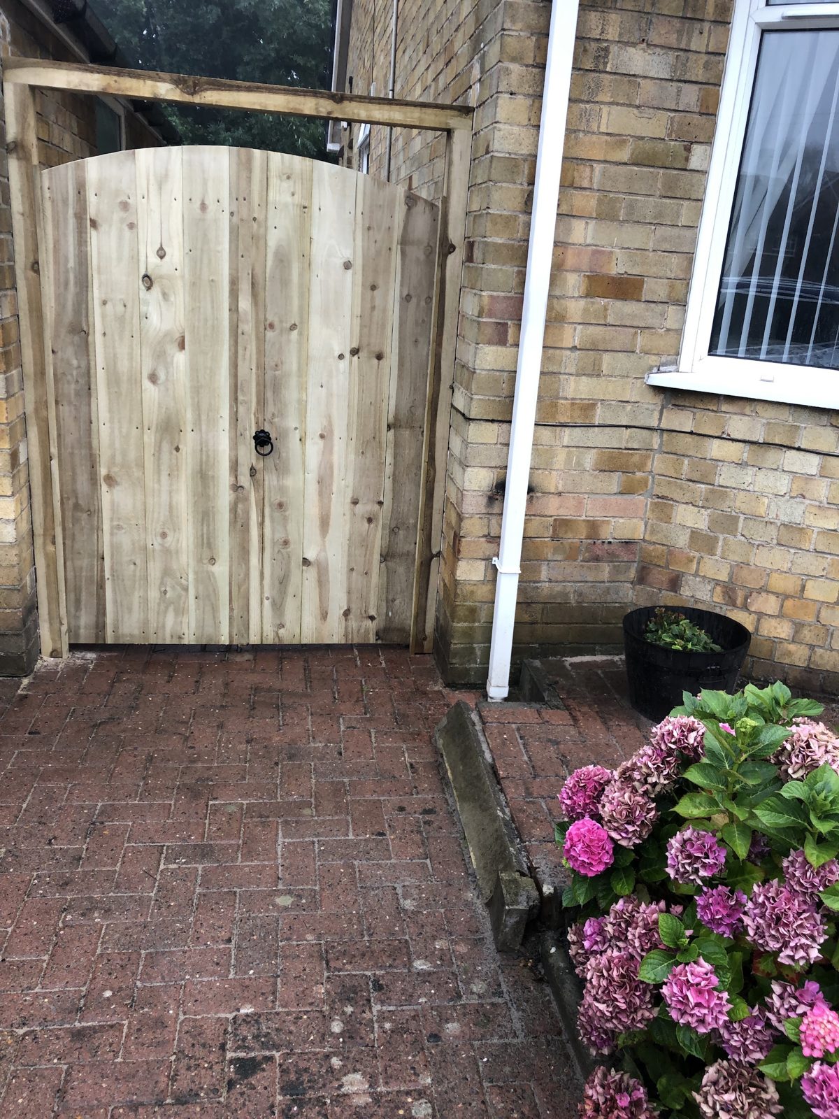 A new timber gate in its own frame at the side of a house