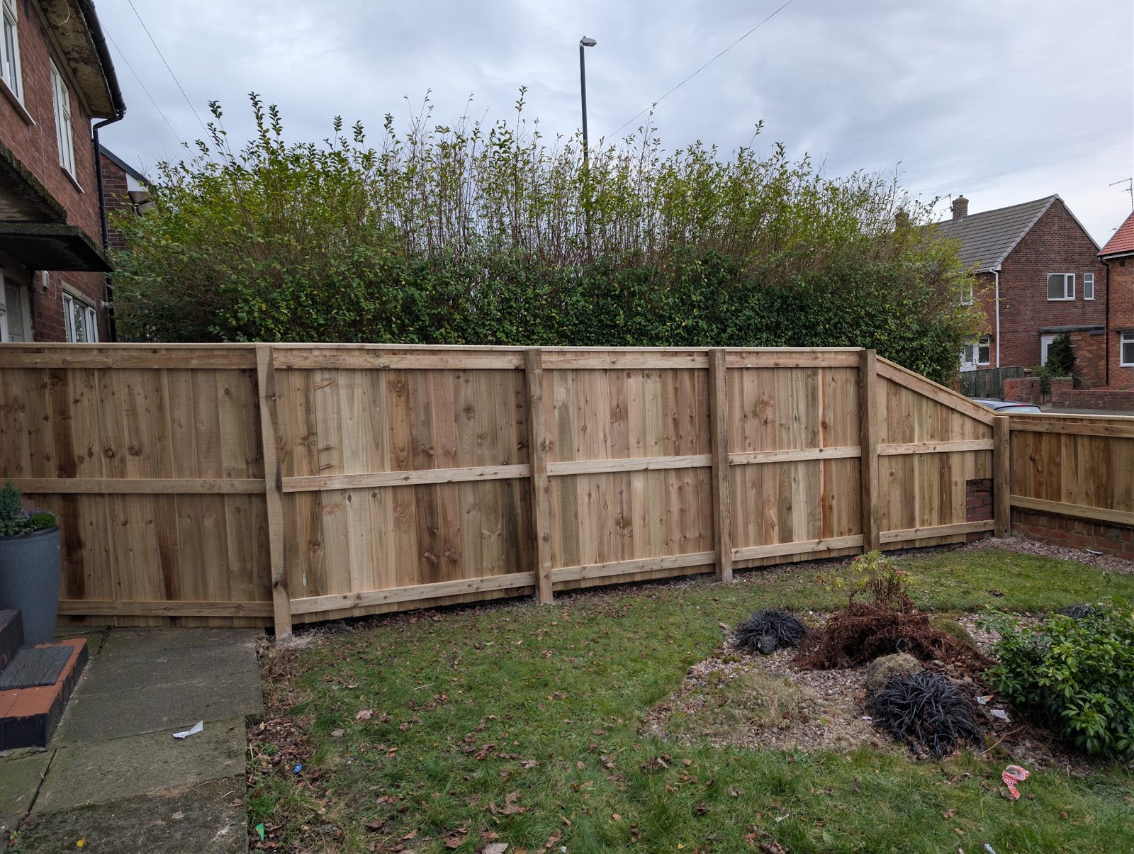 A featheredge panel fence stepping down a front garden